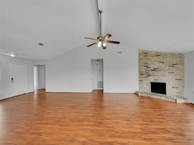 unfurnished living room with a brick fireplace, visible vents, light wood finished floors, and ceiling fan