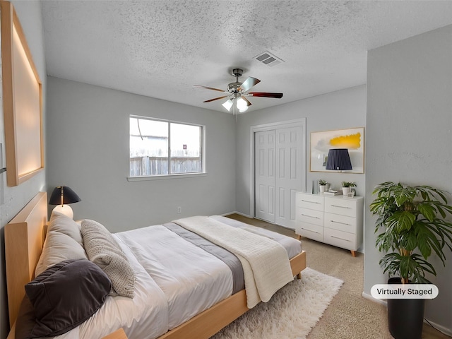 bedroom with visible vents, a textured ceiling, a closet, and carpet flooring