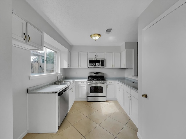 kitchen with visible vents, light tile patterned floors, appliances with stainless steel finishes, white cabinetry, and a sink