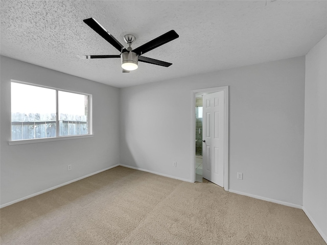 empty room with a ceiling fan, baseboards, a textured ceiling, and carpet flooring