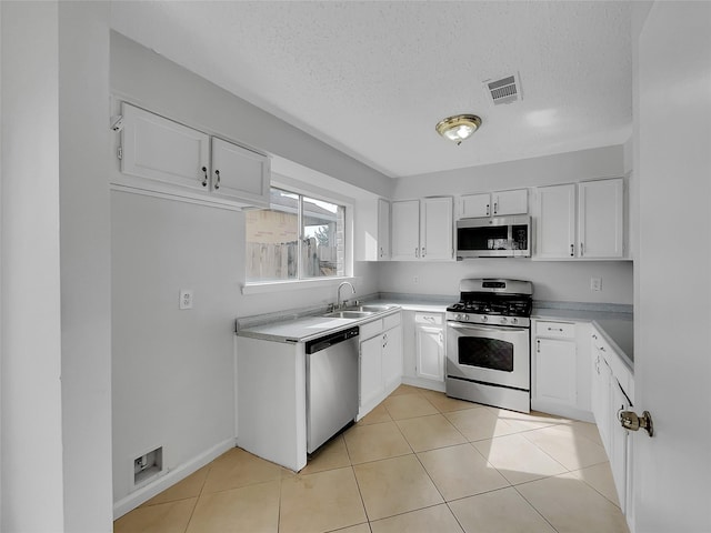 kitchen featuring white cabinets, visible vents, appliances with stainless steel finishes, and a sink