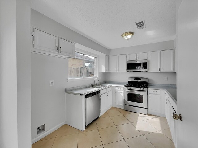 17103 Costero Dr, Houston, TX 77083 - kitchen with a sink, appliances with stainless steel finishes, white cabinetry, and visible vents