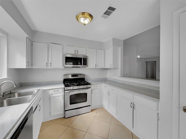 17103 Costero Dr, Houston, TX 77083 - kitchen with visible vents, light countertops, a sink, appliances with stainless steel finishes, and light tile patterned floors