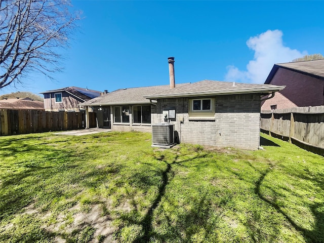 back of property with brick siding, cooling unit, a yard, a fenced backyard, and a patio