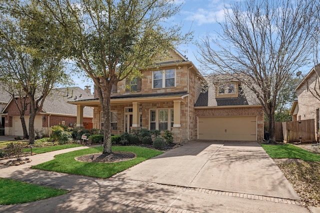 view of front of house with a front lawn, fence, stone siding, and driveway