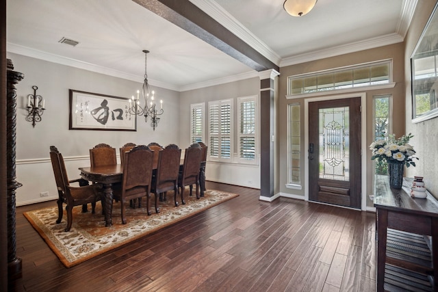 dining room with baseboards, visible vents, dark wood-type flooring, crown molding, and a chandelier