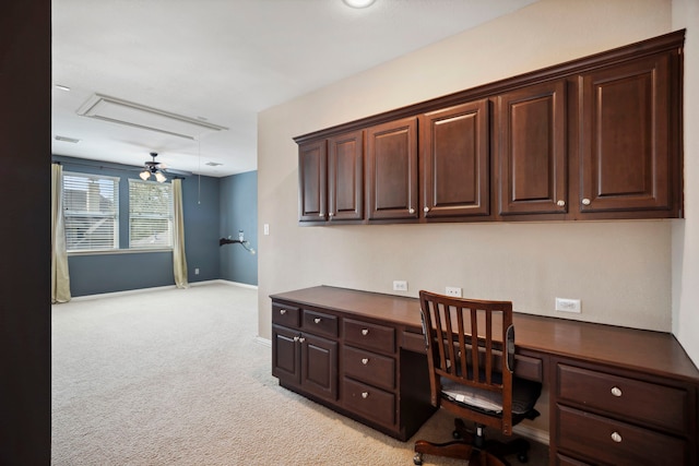 office space featuring baseboards, light colored carpet, attic access, and built in study area