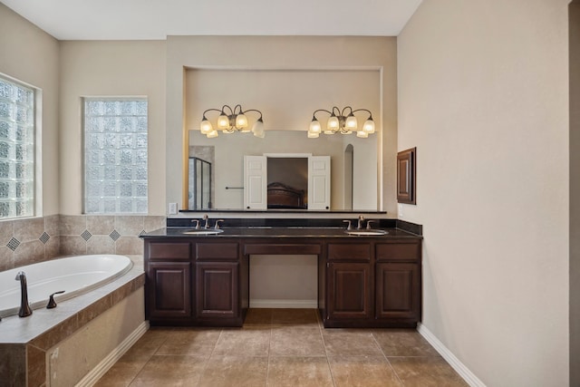 bathroom featuring double vanity, a shower with door, a garden tub, and a sink