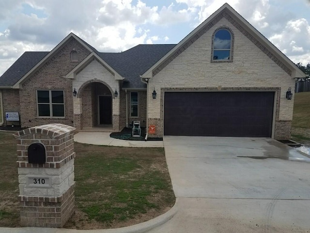 view of front of home with brick siding, concrete driveway, a garage, and a shingled roof