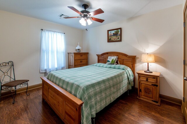 bedroom featuring dark wood finished floors, visible vents, baseboards, and a ceiling fan