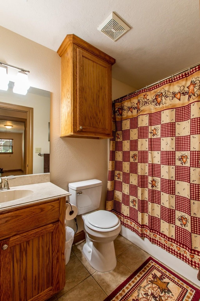 bathroom featuring vanity, visible vents, a textured ceiling, tile patterned floors, and toilet