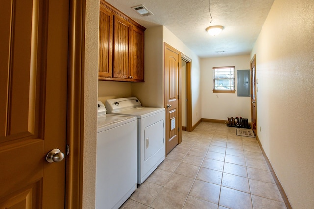 clothes washing area with visible vents, washer and clothes dryer, a textured ceiling, cabinet space, and light tile patterned floors