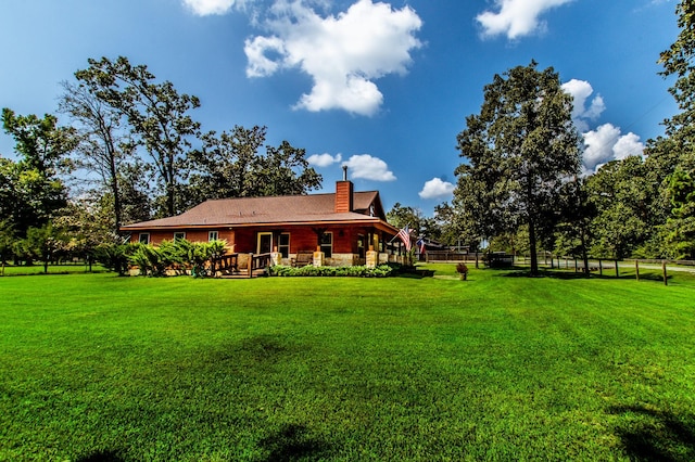 back of property with a yard, a chimney, and fence