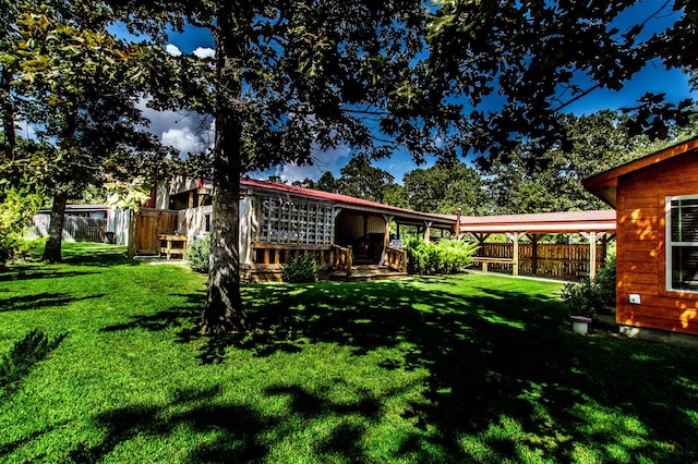 back of property featuring a wooden deck, a lawn, and fence