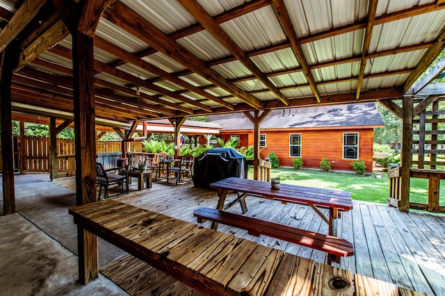 wooden deck featuring outdoor dining area, a yard, and grilling area