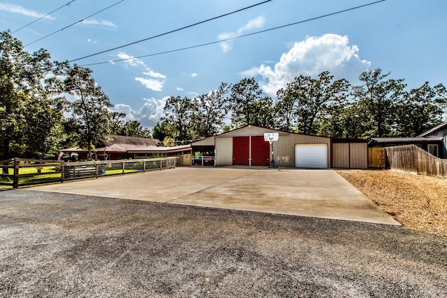 exterior space featuring an outbuilding, fence, and driveway