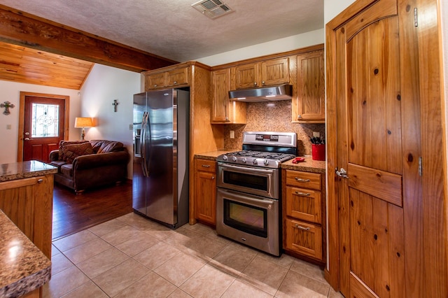 kitchen with under cabinet range hood, stainless steel appliances, visible vents, and brown cabinetry