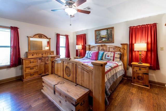 bedroom featuring dark wood-style floors, visible vents, a ceiling fan, and baseboards