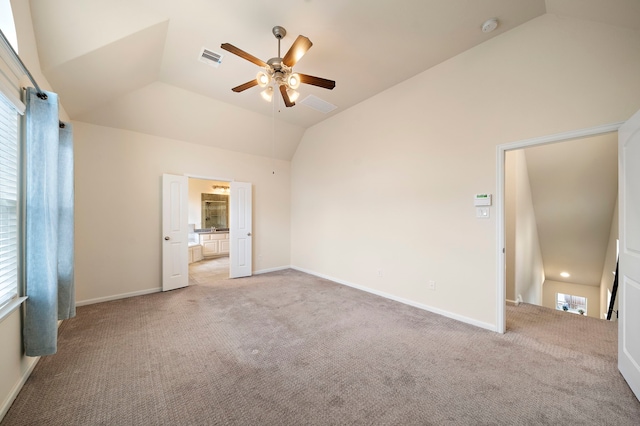 unfurnished bedroom featuring visible vents, light colored carpet, baseboards, and vaulted ceiling