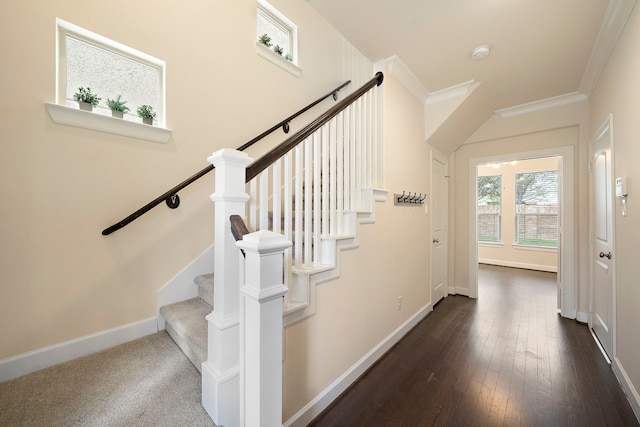 stairs with wood-type flooring, baseboards, and ornamental molding