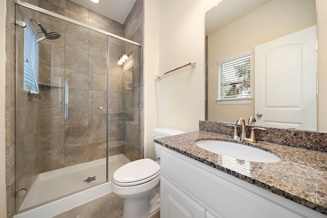 bathroom featuring a stall shower, toilet, and vanity