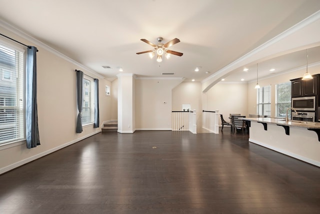 unfurnished living room featuring a wealth of natural light, baseboards, and dark wood-style flooring