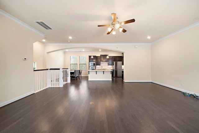 unfurnished living room with visible vents, ornamental molding, baseboards, and dark wood-style flooring