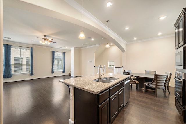 kitchen featuring dark wood-style floors, open floor plan, stainless steel appliances, and a sink