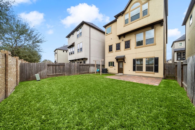 back of house featuring central air condition unit, stucco siding, a fenced backyard, a yard, and a patio