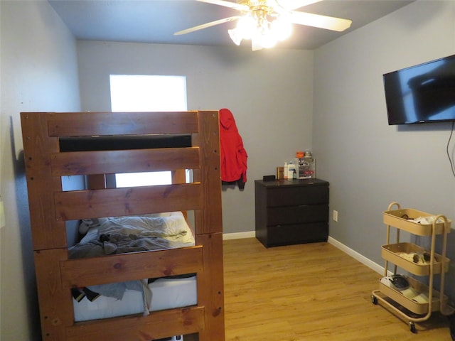 bedroom with baseboards, wood finished floors, and a ceiling fan