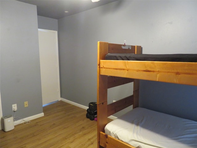 bedroom featuring light wood finished floors and baseboards