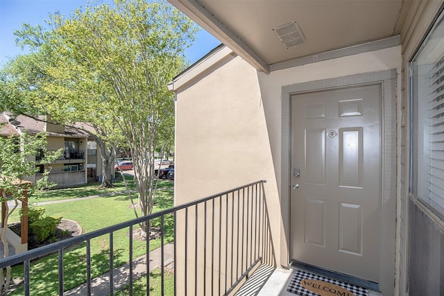 view of exterior entry featuring visible vents and stucco siding