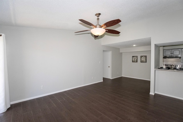 unfurnished living room featuring ceiling fan, baseboards, a textured ceiling, and dark wood-style floors