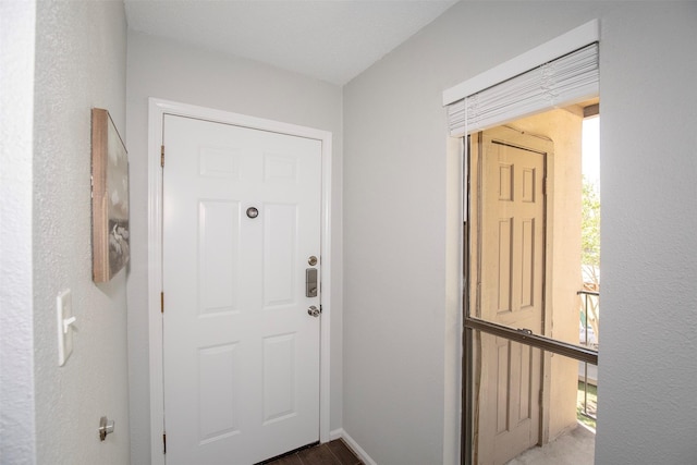 doorway featuring baseboards