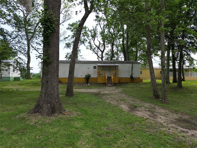 back of property with a yard and entry steps
