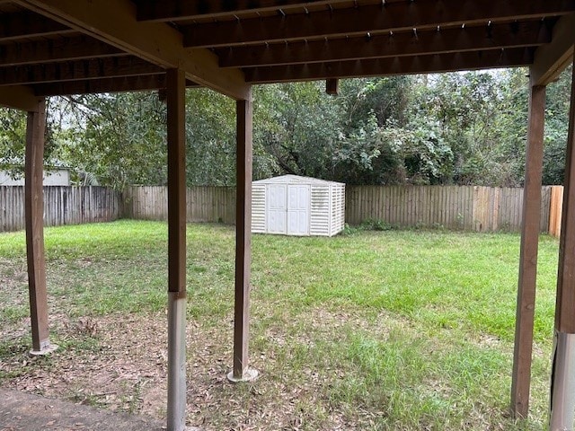 view of yard with a fenced backyard, a storage shed, and an outdoor structure