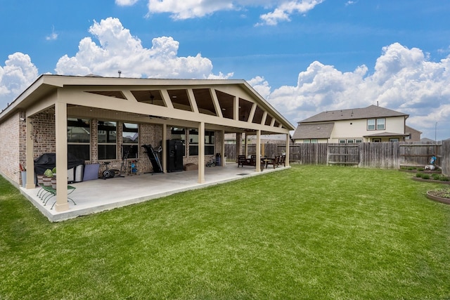 back of house with brick siding, a fenced backyard, and a patio area