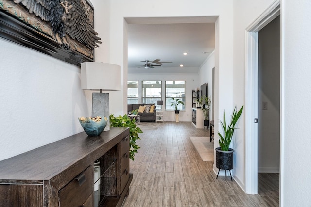 hall with recessed lighting, light wood-type flooring, and baseboards