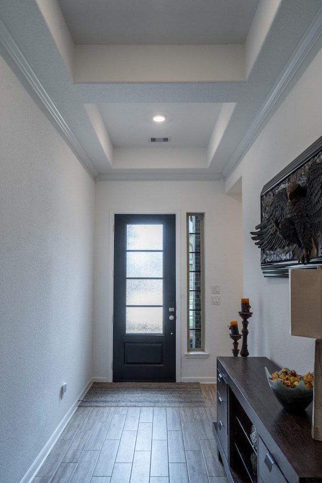 entryway featuring visible vents, a raised ceiling, and baseboards