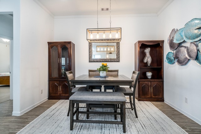 dining area featuring baseboards, wood finished floors, and ornamental molding