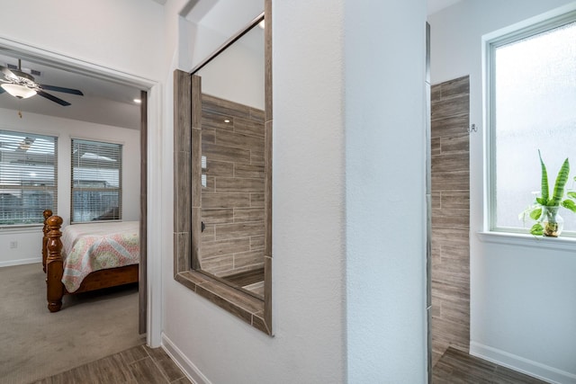 ensuite bathroom featuring wood finish floors, ensuite bathroom, and baseboards