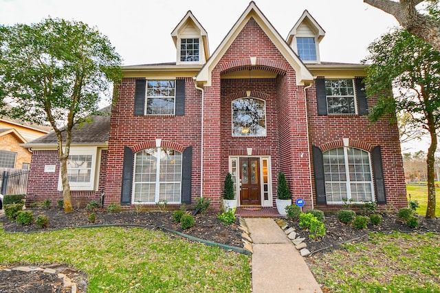 traditional-style house with brick siding and a front lawn