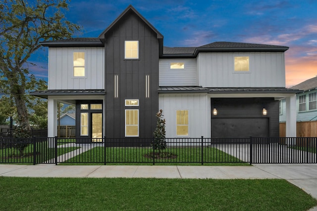 modern farmhouse style home with a standing seam roof, a front yard, board and batten siding, and a fenced front yard