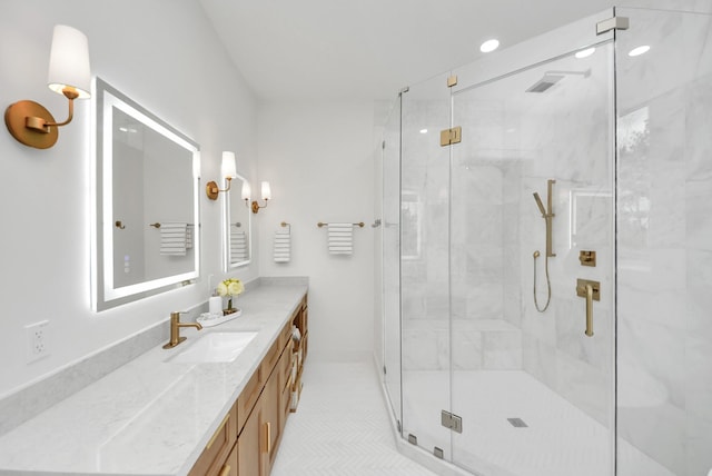 full bathroom with a marble finish shower and vanity