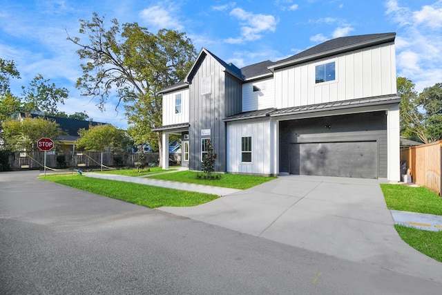 modern farmhouse style home with a front yard, fence, a standing seam roof, a garage, and board and batten siding