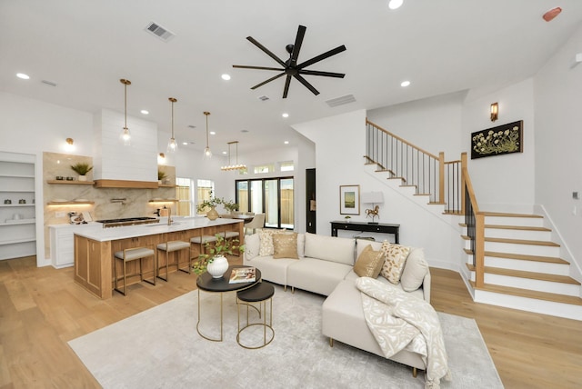 living area with stairway, recessed lighting, light wood-type flooring, and visible vents