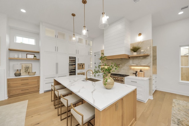 kitchen featuring open shelves, tasteful backsplash, a breakfast bar area, and a sink