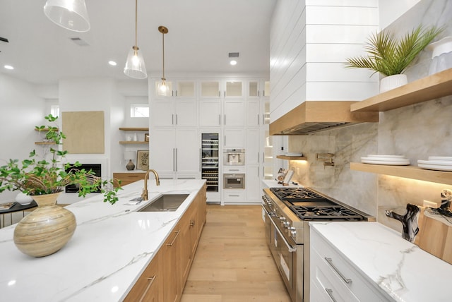 kitchen featuring decorative backsplash, open shelves, high end range, and a sink