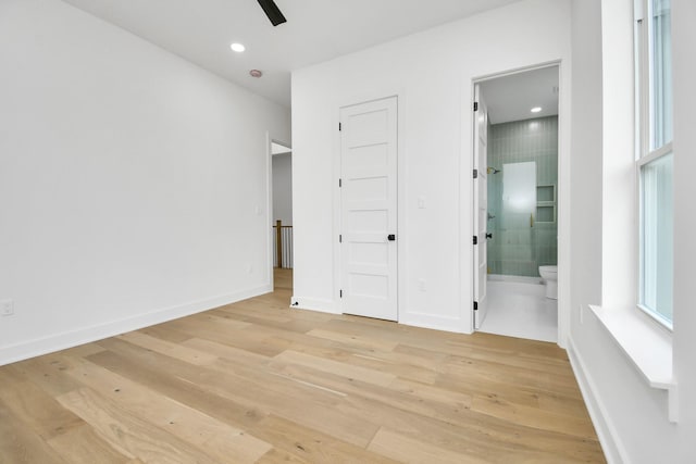 unfurnished bedroom featuring light wood-type flooring, a ceiling fan, recessed lighting, connected bathroom, and baseboards