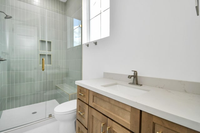 full bathroom with a stall shower, toilet, and vanity